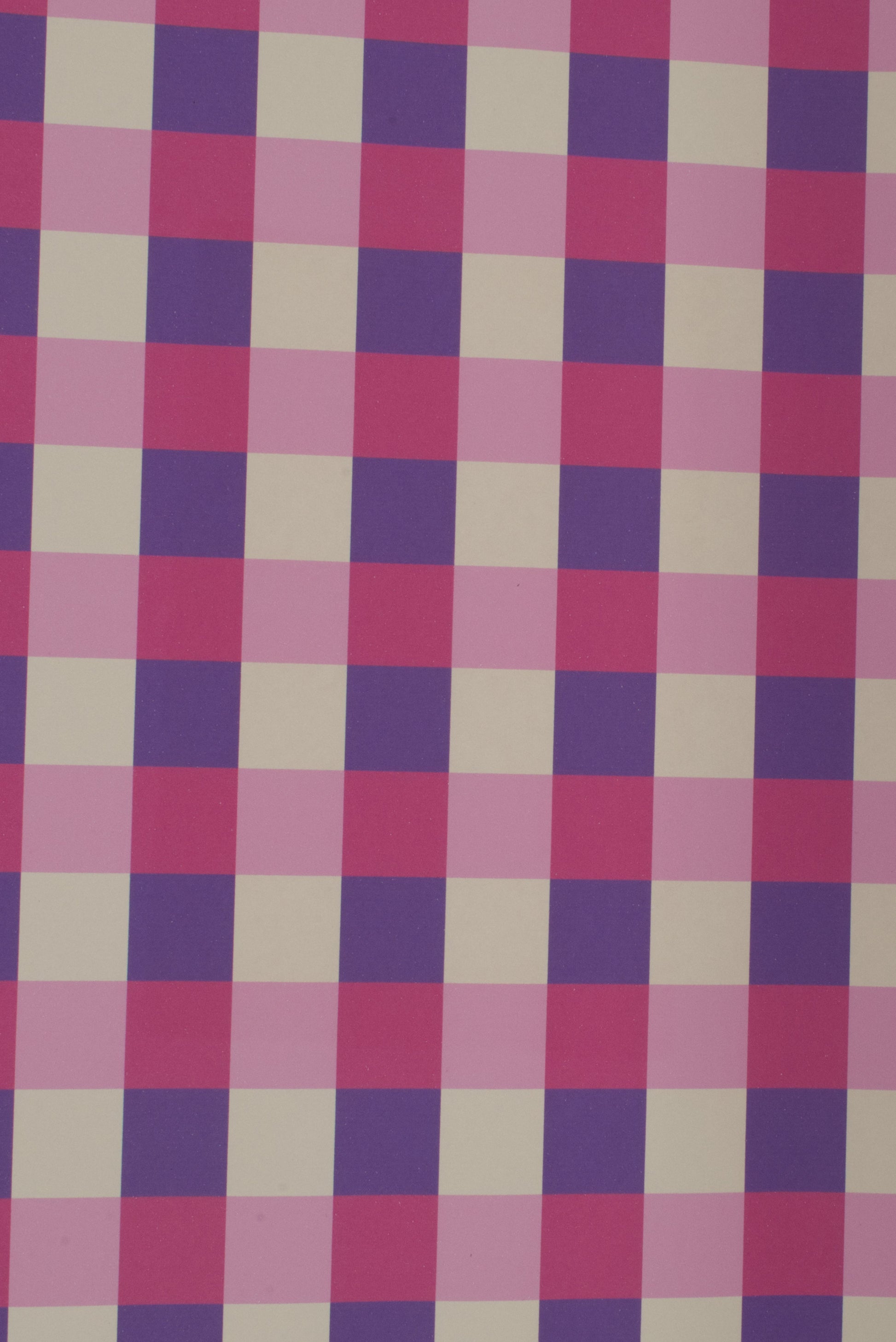 Checkered fabric with a pattern of pink, purple, and beige squares on a white background